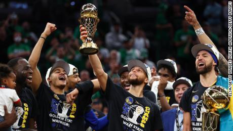 Curry raises the Bill Russell NBA Finals MVP Award after defeating the Celtics in Game 6 的 2022 NBA总决赛.