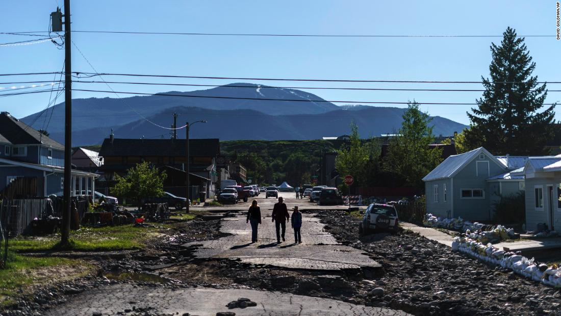 Pedestrians walk down a damaged street in Red Lodge on Wednesday. 