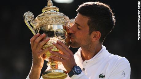 Djokovic kisses the trophy after defeating Kyrgios in the men&#39;s singles final at Wimbledon.