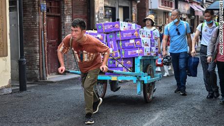 A man hauls a cart loaded with coconuts at Gulangyu Island in Xiamen, Fujian province on July 24, 2022.