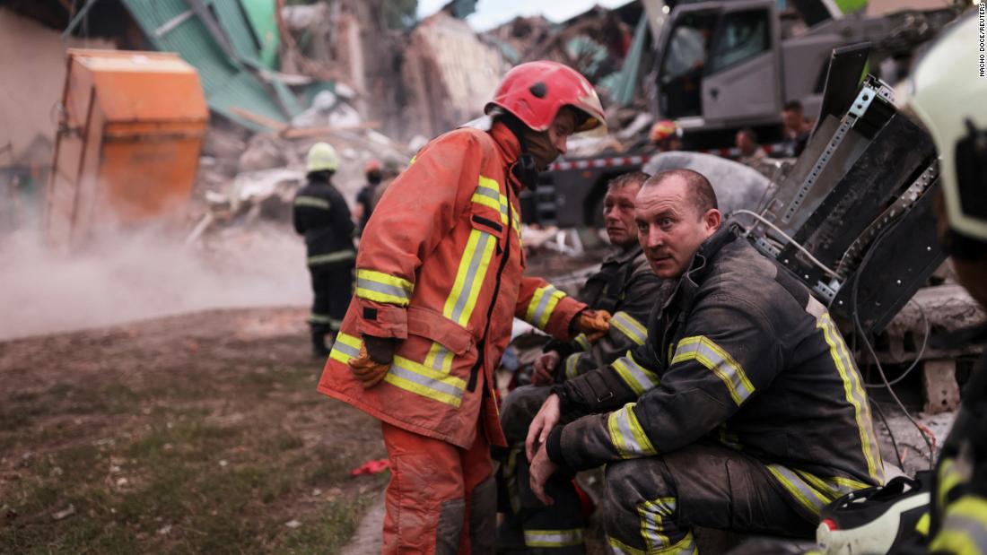 Firefighters rest as their colleagues remove debris during the search for bodies at the Central House of Culture, in Chuhuiv, Ucraina, after an air strike on July 25.
