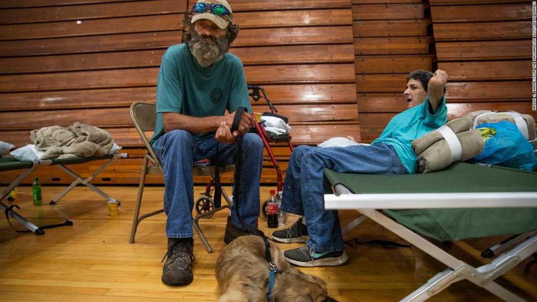Robert Hollan, Kimberly DiVietri and their dog, ラスカル, wait in a shelter inside the Hazard Community College Lee&#39;s College campus on Thursday.
