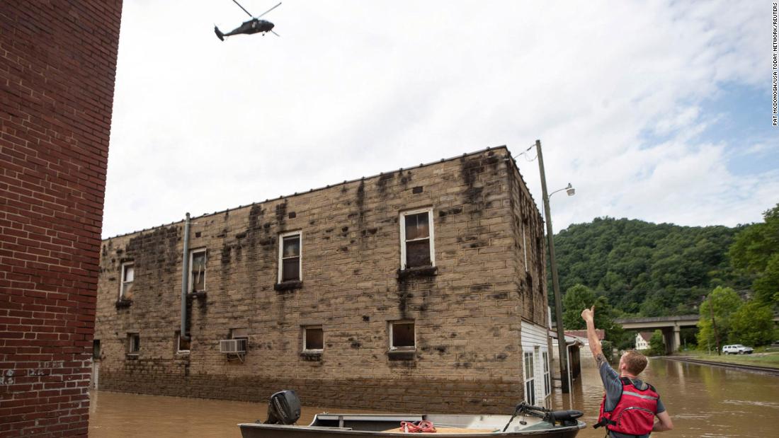 James Jacobs signals to a National Guard helicopter flying overhead in Garrett, Kentucky, di giovedì.