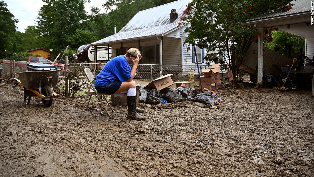 Teresa Reynolds sits exhausted as members of her community clean debris from flood-ravaged homes in Hindman, Kentucky, op Saterdag, Julie 30.