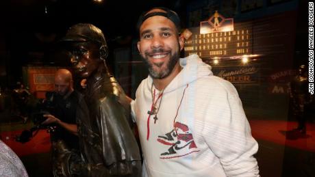 Dodgers pitcher David Price poses with a statue of Jackie Robinson.