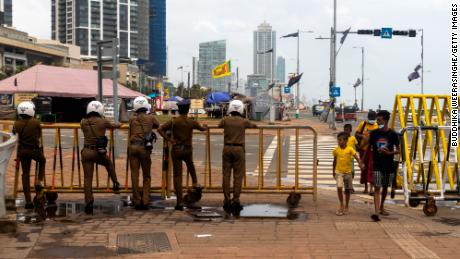 Police officers stand behind the security barricade near a protest camp in Colombo, Sri Lanka, on August 5, 2022
