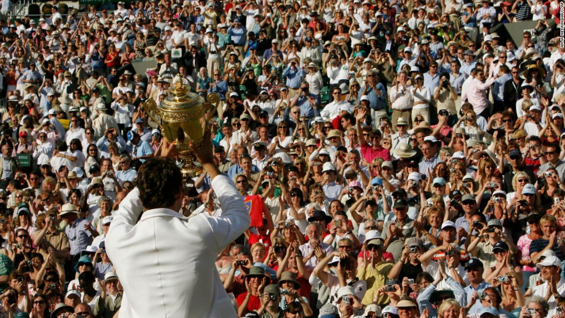 Federer holds up his trophy to the crowd after winning his fifth straight Wimbledon in 2007.