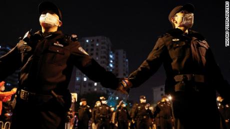 Police officers stand guard as people protest coronavirus disease (COVID-19) restrictions and hold a vigil to commemorate the victims of a fire in Urumqi, as outbreaks of the coronavirus disease continue, in Beijing, China, November 27, 2022. REUTERS/Thomas Peter 