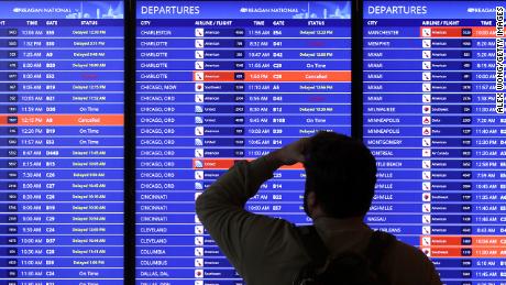 A traveler looks at a flight information board at Ronald Reagan Washington National Airport on January 11, 2023 in Arlington, Virginia. 