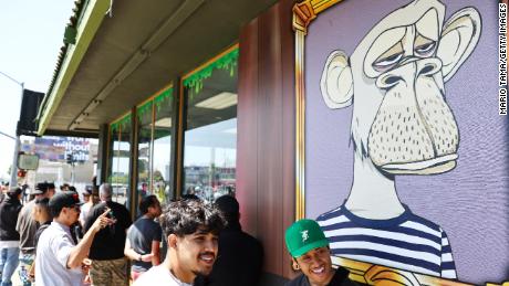 People wait in line at the April 2022 grand opening of the Bored &amp; Hungry pop-up burger restaurant in Long Beach, California, which used Bored Ape images. 