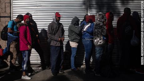 Migrants wait in line outside at the Mexican Commission for Refugee Assistance in Mexico City, Mexico, on January 24, 2023.