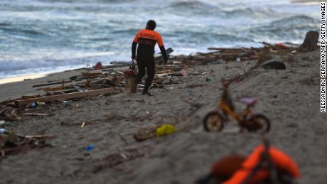 A policeman and his dog patrol the beach on February 26, 2023, where debris of a shipwreck was washed ashore after a migrants&#39; boat sank off Italy&#39;s southern Calabria region.