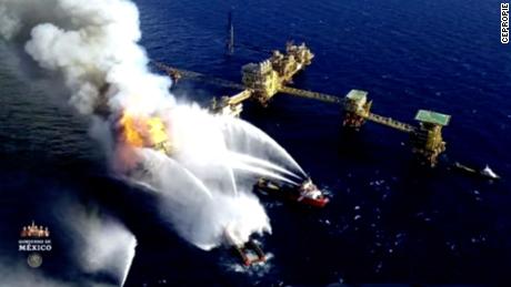 Emergency crews work to put out a fire at the Nohoch Alfa oil platform in this photo shown at a press conference with Mexican President Andrés Manuel López Obrador.