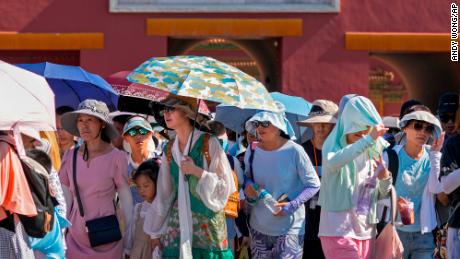 Visitors wear sun hats and carry umbrellas as they leave the Forbidden City on a hot day in Beijing, Thursday, June 29, 2023. The entire planet sweltered for the two unofficial hottest days in human recordkeeping Monday and Tuesday, according to University of Maine scientists at the Climate Reanalyzer project. The unofficial heat records come after months of unusually hot conditions due to climate change and a strong El Nino event. (AP Photo/Andy Wong)