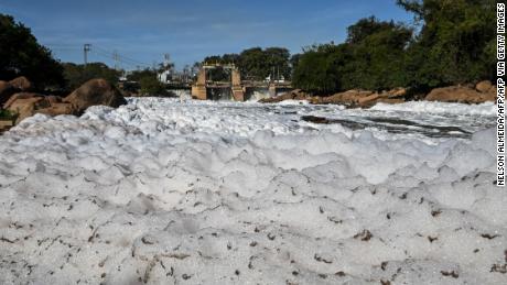 View of the Tiete river covered with toxic foam in Salto, 100km from Sao Paulo, Brazil on July 7, 2023. The Tiete River is 1,100 km long, crossing the state of Sao Paulo, and during the dry season, the sewage that is dumped into the river in the metropolitan region of Sao Paulo forms a toxic foam composed of phosphates and phosphorus present in biodegradable household products such as soap, detergent, soap, toothpaste and shampoo, causing pollution. (Photo by NELSON ALMEIDA / AFP) (Photo by NELSON ALMEIDA/AFP via Getty Images)