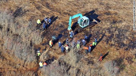 FILE - In this Dec. 8, 2011 photo, investigators use a backhoe to dig while searching for Shannan Gilbert&#39;s body in different sectors of a marsh area just east of Oak Beach, N.Y. A Long Island architect has been charged, Friday, July 14, 2023, with murder in the deaths of three of the 11 victims in a long-unsolved string of killings known as the Gilgo Beach murders. (AP Photo/Kevin P. Coughlin, File)
