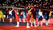 Children hold flags during the opening ceremony.