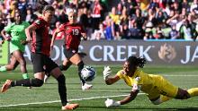 Nigerian goalkeeper Chiamaka Nnadozie clears the ball after saving a penalty by Canada's Christine Sinclair.