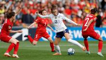 US forward Alex Morgan is surrounded by Vietnam defenders during their opening match on July 22. The United States, the two-time defending champs, won 3-0.
