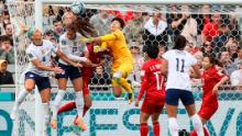 Players collide in the box as Vietnam goalkeeper Trần Thị Kim Thanh looks to clear the ball away.