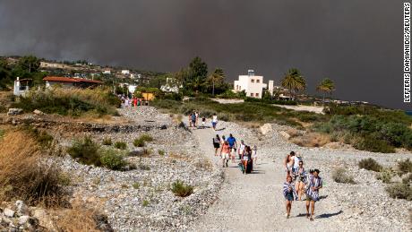 Tourists are being evacuated as wildfire burns near Lindos, on the island of Rhodes, Greece, July 22, 2023. 
