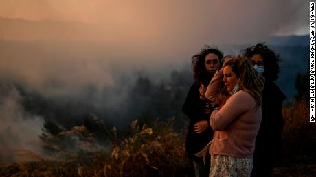 Villagers watch the progression of a wildfire as it approaches Zambujeiro village in Cascais, Portugal on July 25, 2023. (Photo by Patricia DE MELO MOREIRA / AFP) (Photo by PATRICIA DE MELO MOREIRA/AFP via Getty Images)