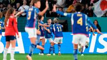 Japan's Hikaru Naomoto, center, celebrates with teammates after scoring the opening goal in the 2-0 victory over Costa Rica on July 26. It was Japan's second win in as many games, and it clinched a spot in the knockout stage.