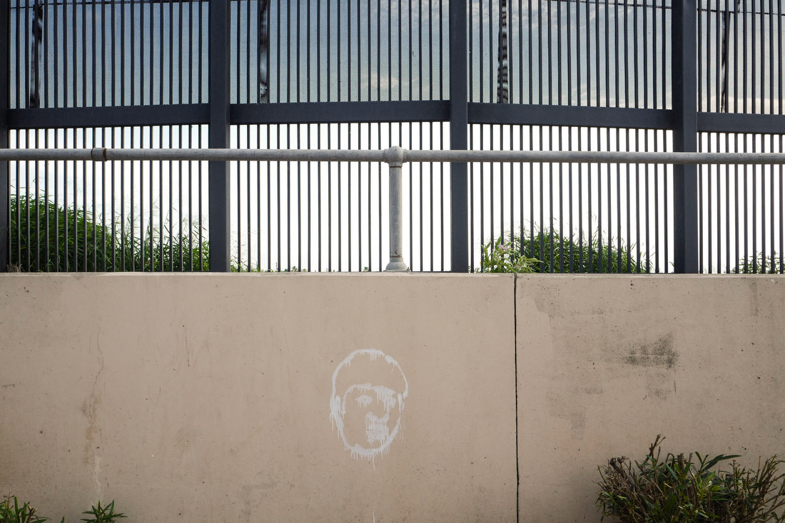 A caricature of Donald Trump spray-painted onto a wall in Hope Park, where a long stretch of fence stands between residents and the border.