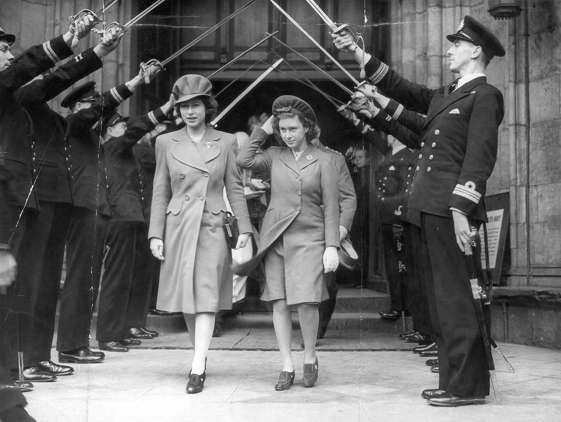 Black and white photo of Princess Elizabeth emerging from a stone church doorway as servicemen hold their swords above the princesses in an archway.  Elizabeth wears a peaked hat and a coat with a brooch.