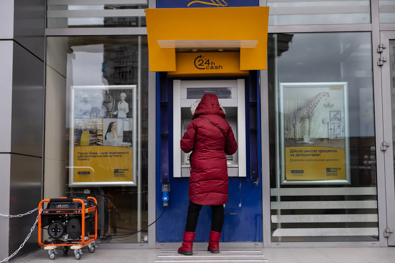 A woman stands at an ATM powered by a generator.