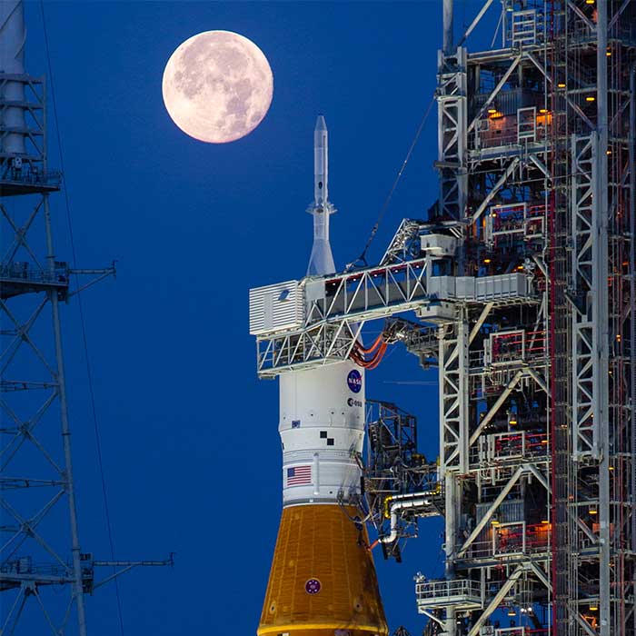 Artemis I rocket is in position at Launch Complex 39B as the full moon lights up the night sky.