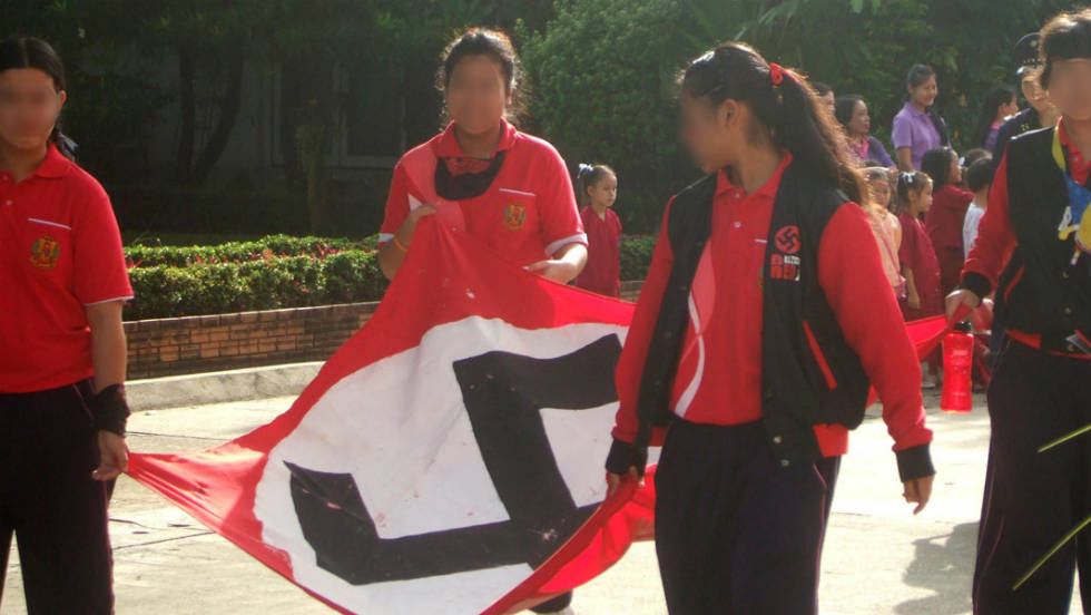 A giant Nazi flag is carried by students along a street in the northern Thai city.
