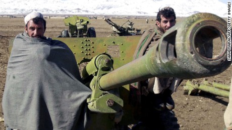 GARDEZ, AFGHANISTAN:  Afghan militiamen Bakhtyar, 37, (R) and Ali Shah , 39, (L) pose in front of a 80 mm rocket launcher during a disarmament cermony in Gardez, the capital of Paktia province, 17 November 2003. About 600 Afghan militiamen handed in their guns in the latest phase of an ambitious disarmament program. AFP PHOTO/SHAH Marai  (Photo credit should read SHAH MARAI/AFP/Getty Images)