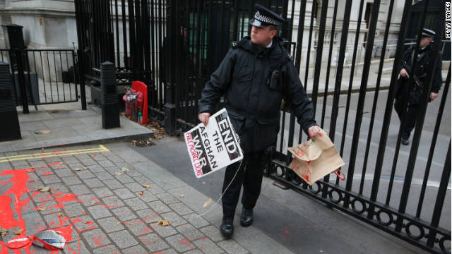A policeman at Downing Street, London, clears away placards left by an anti-war protest on the 10-year anniversary. 