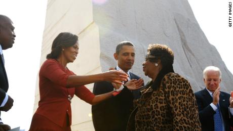 First Lady Michelle Obama reaches out to embrace Aretha Franklin as President and CEO of the Martin Luther King, Jr. National Memorial Project Foundation Harry Johnson (L), US President Barack Obama , Vice President Joe Biden (3rd R), Biden&#39;s wife Jill and Interior Secretary Ken Salazar (R) look on after Franklin performed at the dedication of the Martin Luther King Jr. Memorial October 16, 2011 in Washington, DC. AFP PHOTO/Mandel NGAN (Photo credit should read MANDEL NGAN/AFP/Getty Images)