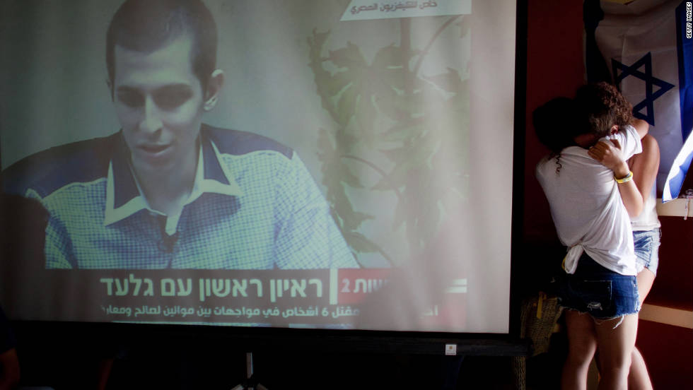 Israelis react after seeing the first images of Shalit on TV following his release.