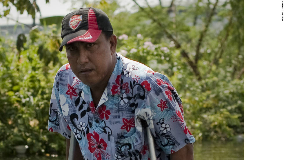 A man walks through floodwaters in Bang Bua Thong on the outskirts of Bangkok Sunday.