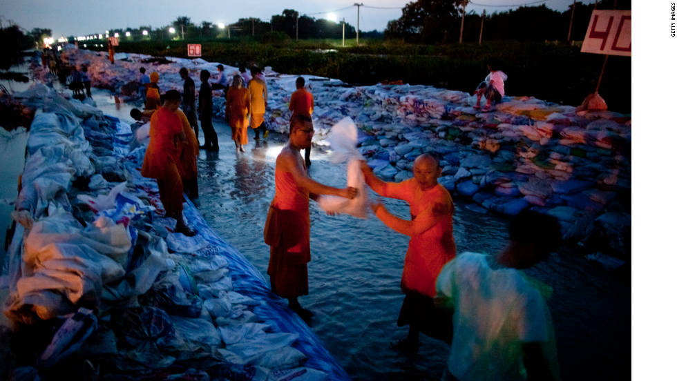 Dhammakaya monks and volunteers work to fortify the flood gate at Klong Rapi Pat Sunday on the outskirts of Bangkok, Thailand.