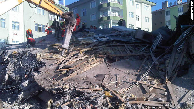 Rescue teams attempt to dig through the rubble of a collapsed building in Ercis looking for survivors.
