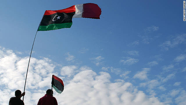 Libyans wave their new national flag and Qatar&#39;s flag during a ceremony announcing the liberation in Benghazi on Sunday.