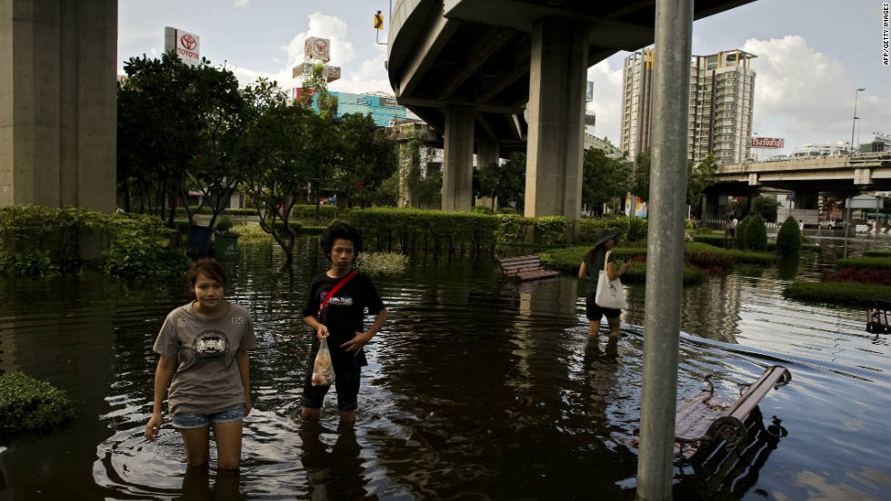 Residents wait for a rescue boat as they evacuate their neighborhood next to the Chao Praya River in Bangkok on Friday. 