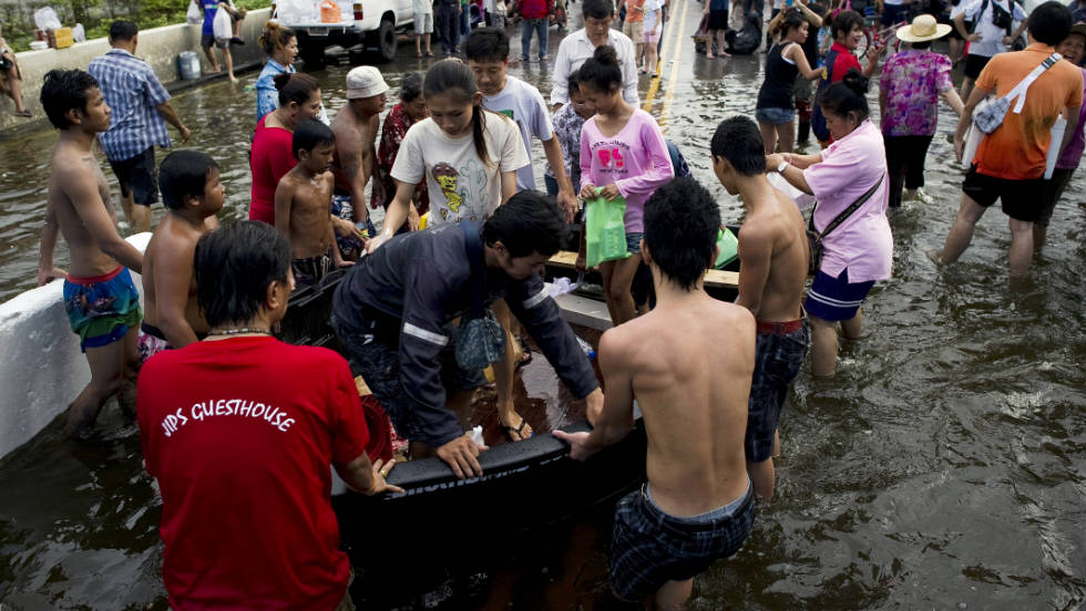 Residents evacuating their neighborhoods get off a rescue boat near the Chao Praya River.