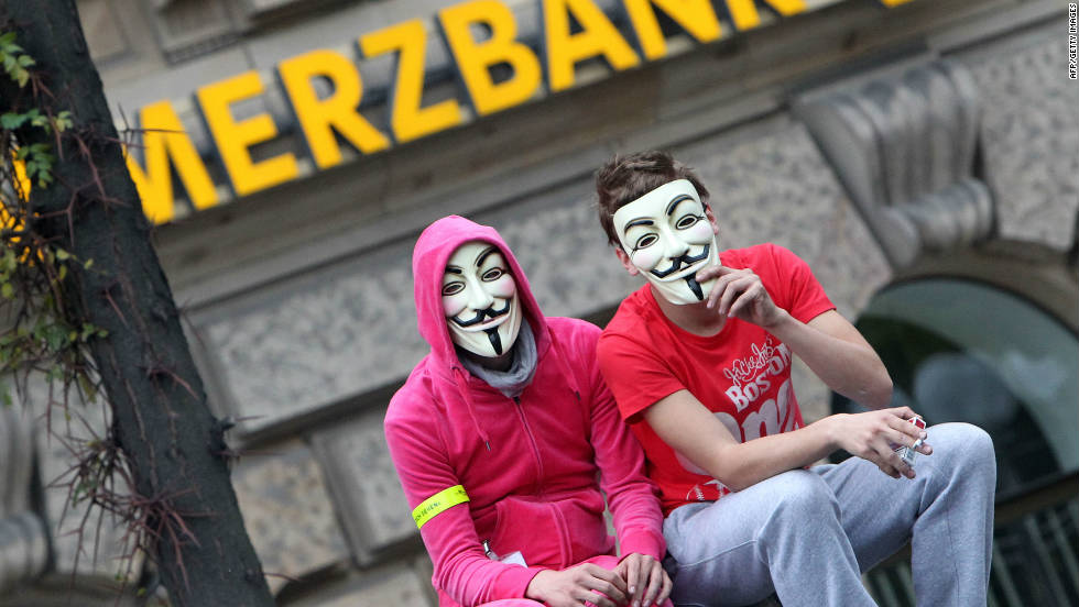 Demonstrators wearing &quot;Vendetta&quot; masks sit in front of a Commerzbank branch in Frankfurt on October 29.