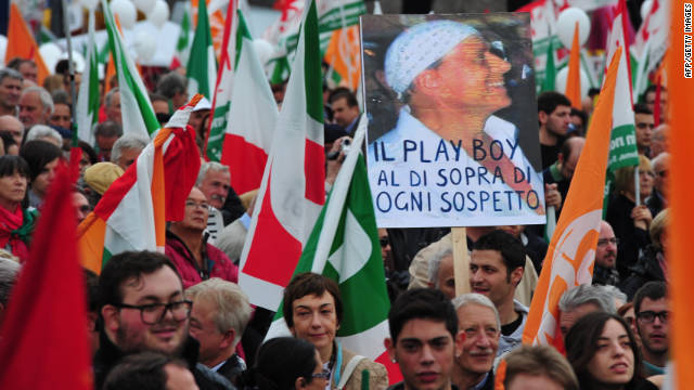 Demonstrators hold a placard of Silvio Berlusconi and reading &quot;The playboy above suspicion&quot; during a protest Saturday in Rome.