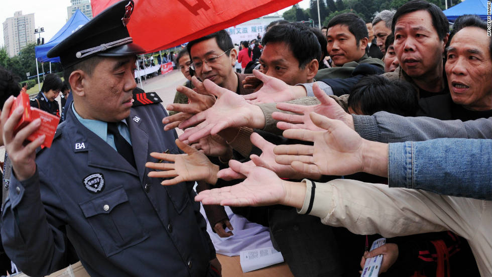 A group of Chinese men gather to collect the free condoms distributed to mark World AIDS Day in Fujian province on December 1, 2010. 