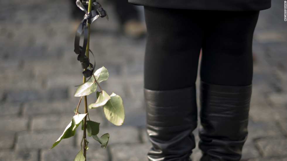 A woman in line holds a rose as she waits to pay respects to Havel on Thursday, December 22.