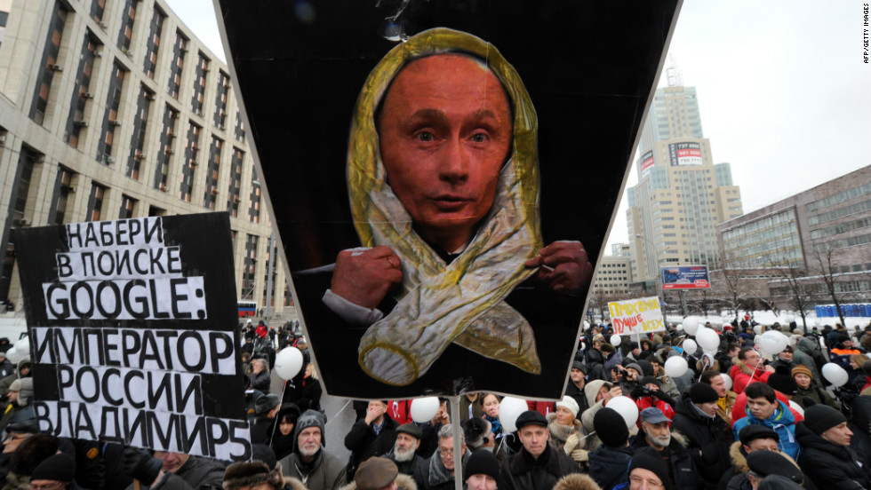 Protesters hold banners mocking Russian Prime Minister Vladimir Putin.