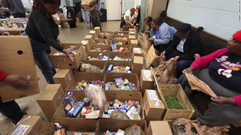 Members pack boxes with a hodgepodge of items ranging from cereal and canned goods to cleaning supplies. 