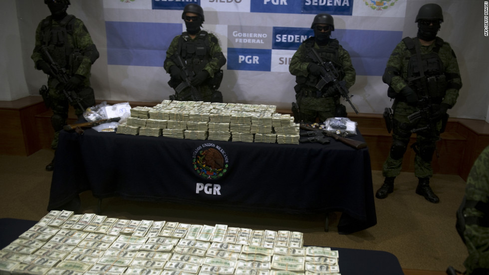 Mexican army soldiers display $15 million U.S. on November 22, 2011, in Mexico City. The money was seized from alleged members of the Guzman Loera drug cartel during a raid in the border town of Tijuana, Mexico.