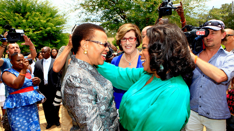 Winfrey greets Graca Machel, the wife of former South African president Nelson Mandela, on her arrival at the inaugural graduation of the class of 2011.